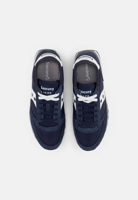 Navy blue Saucony Jazz sneakers with white accents, mesh and suede upper, lace-up design, and cushioned sole for comfort.