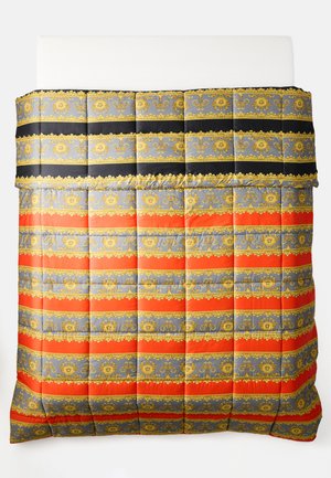Quilted bedcover with horizontal stripes in black, red, gray, and gold ornate baroque patterns on a white bed.