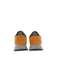 Orange suede running shoes with a black upper heel and gray sole, featuring bold “SINCE 1890” branding on the heel.