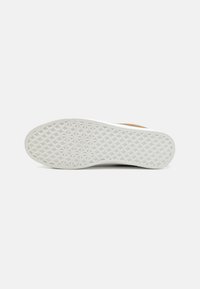 Shoe sole with a textured white rubber surface, featuring a geometric pattern. No visible branding or features on the side.