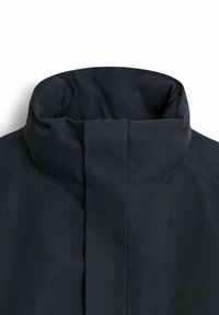 Marinblå jackkrage med en hög design, som har en slät, matt yta och en dold framdragkedja.