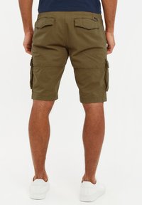 Olivgrüne Cargo-Shorts aus robustem Stoff, ausgestattet mit Seitentaschen, Gesäßtaschen und einer lässigen Passform, kombiniert mit weißen Sneakers.