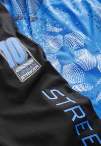Pantalones cortos deportivos negros y azules que presentan un patrón texturizado, gráficos audaces y diseños contrastantes con el texto "10" y "STREET".