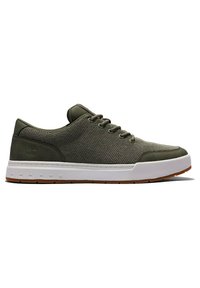 Gröna mesh-sneakers med vit mellansula och brun gummisula. Utrustad med runda snören och förstärkt tåhätta. Minimal varumärkning på hälen.