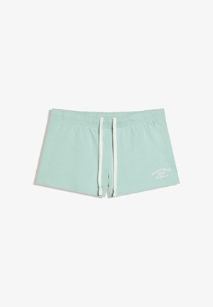 Short bleu clair à cordon avec taille élastique et texte blanc « Venice beach 1985 California » sur la partie inférieure de la jambe droite.