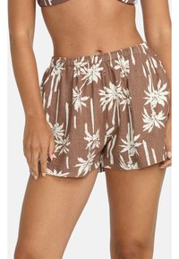 Brune stofshorts med et hvidt palmebladsmønster. Har en elastisk talje og en afslappet pasform. Struktureret overflade.