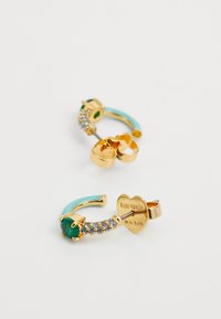 Orecchini a cerchio in tono oro con accenti turchesi e pietra verde. Presentano un cluster di gemme blu decorative e un'etichetta a forma di cuore.