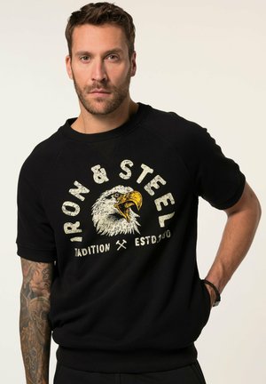 Sort kortærmet sweatshirt med en ørn grafik og teksten "Iron & Steel" i slidte hvide og gule farver. Ribbet halsudskæring og manchetter.