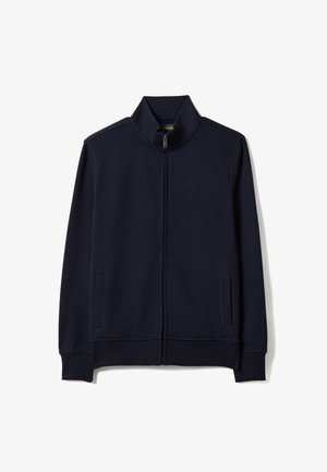 Chaqueta azul marino con cremallera, cuello alto, puños y dobladillo acanalados, y dos bolsillos verticales en los lados.