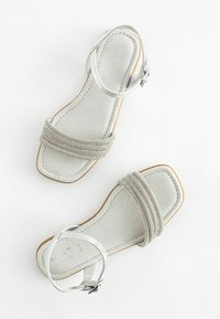 Zilveren sandalen met een gestructureerde band versierd met kralen, een verstelbare enkelgespsluiting en een vierkante teenvorm met een platte zool.