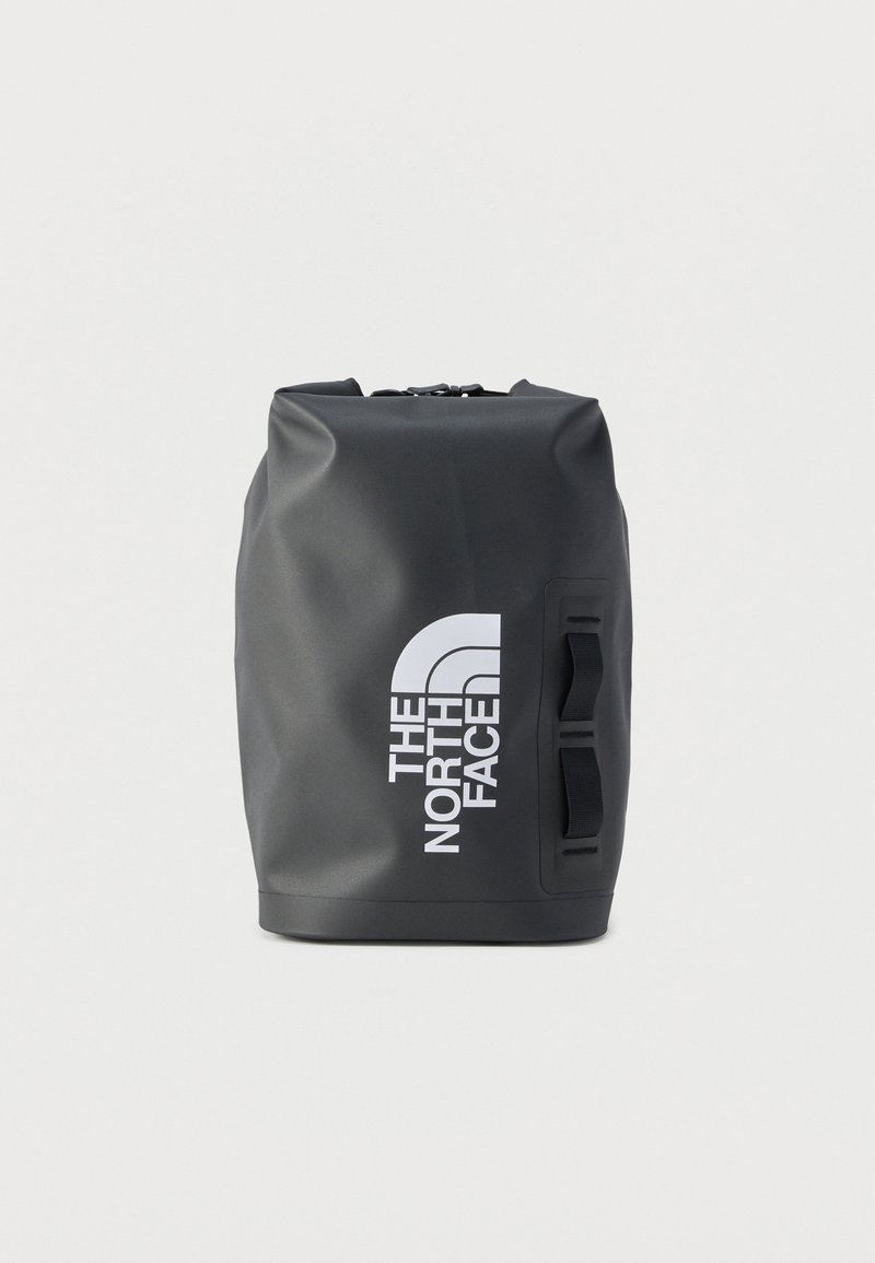 Μαύρο αδιάβροχο σακίδιο πλάτης με ρολό στην κορυφή, δύο πλαϊνά λουριά και μεγάλο λευκό λογότυπο "The North Face" μπροστά.