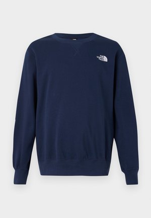 Mornarsko plava majica s kapuljačom izrađena od mekane tkanine, s okruglim izrezom, dugim rukavima i bijelim logotipom na prsima. Glatka tekstura i jednostavan dizajn.