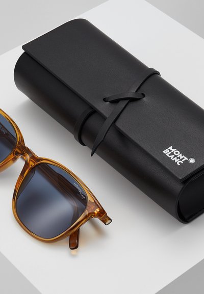 Ochelari de soare Montblanc cu rame de tartă de broască țestoasă de culoare chihlimbar și lentile întunecate, alături de un toc din piele neagră cu închidere prin legătură și logo.
