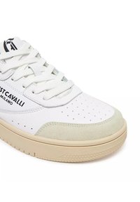 Sneaker bianca in pelle con punta in suede beige, perforazioni, lacci bianchi e logo "Just Cavalli Milano" sul lato.