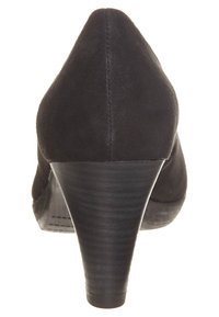 Černá zamšová vysoká dámská bota na podpatku s špičatou špičkou a mírně zakřiveným klínovým podpatkem. Zadní pohled zvýrazňuje hladký povrch a jemné detaily švů.