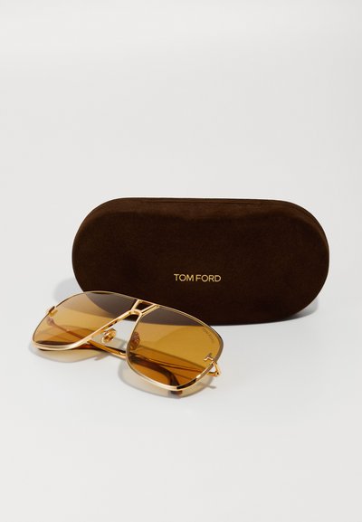 Tom Ford pilotenbril met een gouden metalen frame, bruin getinte lenzen, hoekig ontwerp en een zachte bruine hoes met een gouden logo.