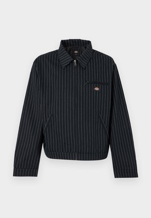 Μαύρο τζάκετ με φερμουάρ και λευκές ρίγες, με μυτερό γιακά, τσέπη στο στήθος με φερμουάρ και δύο πλαϊνές τσέπες, με μικρό στρογγυλό λογότυπο μάρκας.