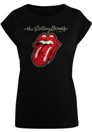 Camiseta negra con un logo de los Rolling Stones en rojo y blanco que presenta un diseño de lengua. Mangas cortas y sueltas; corte relajado; tejido suave.