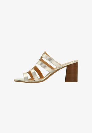 Gold metallic open-toe heeled sandal with three wide straps and a sturdy brown block heel. Smooth texture and minimalist design.