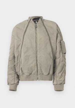 Khaki-Bomberjacke aus strukturiertem Material. Mit einem hohen Kragen, einem Frontreißverschluss und seitlichen Taschen. Bündchen und Saum in Rippstrick runden das Design ab.