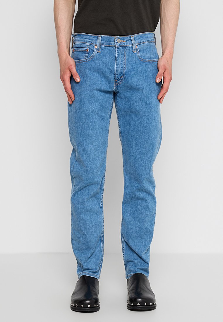 Jeans bleu clair au design droit, dotés de poches avant standard, d'une fermeture à bouton et de détails de couture discrets.