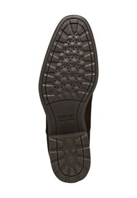 Suola di scarpa in gomma nera con superficie testurizzata, caratterizzata da motivi circolari e piccole perforazioni. Include il marchio "GEOX ULTRA COMFORT".