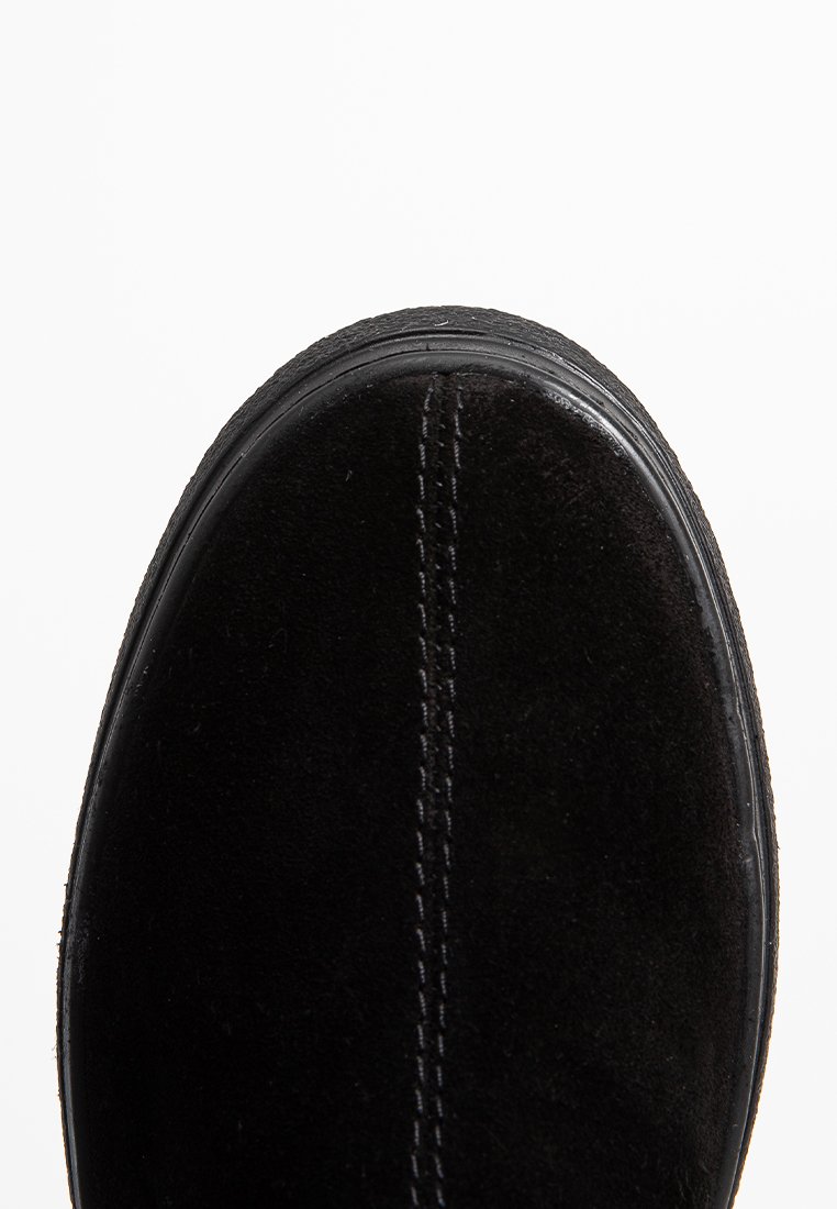 Schwarze Wildleder-Sneaker mit runder Zehenform, auffälliger Naht entlang der Mitte und einer strukturierten Gummisohle. Einfaches Design ohne sichtbare Akzente.