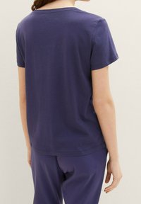 Mörkblått bomullströja med korta ärmar, rundad halsringning och enkel design. Slät textur, utan dekorationer och utan synliga mönster.