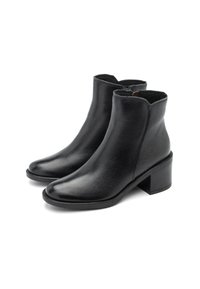 Ein Paar schwarze Leder-Stiefeletten mit Blockabsätzen und seitlichen Reißverschlüssen auf einem weißen Hintergrund.