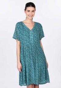 Blumenbedrucktes, kurzärmeliges Kleid in Türkis mit V-Ausschnitt, leicht gerafftem Bund und fließendem Rock; der Stoff wirkt leicht und strukturiert.