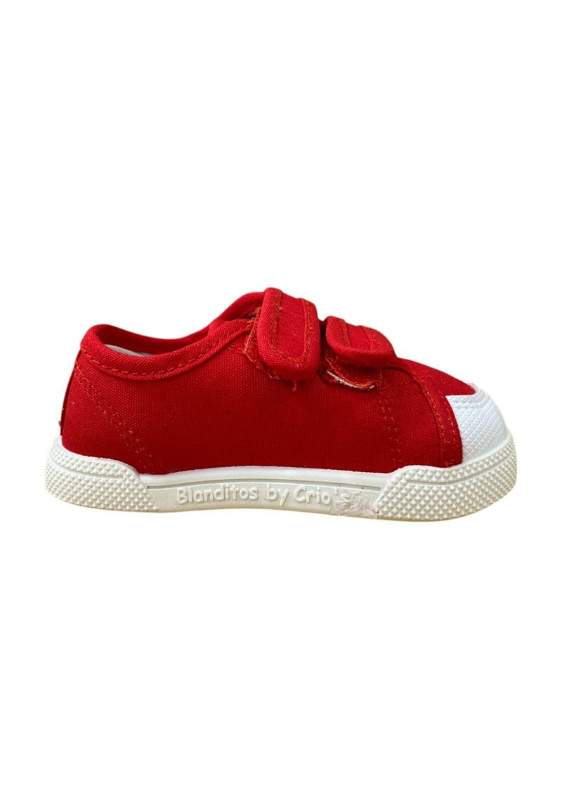 Zapatilla de lona roja con tapa de goma blanca en la puntera y suela texturizada. Presenta dos correas de velcro para un fácil ajuste.