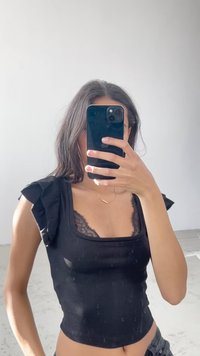 Černý žebrovaný crop top s volánkovými ramenními akcenty a krajkovým lemováním. Úzce přiléhavý střih s čtvercovým výstřihem a jemnou texturou.