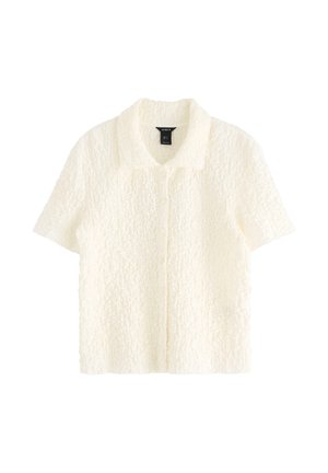 Camicia a maniche corte con bottoni in tessuto bianco testurizzato. Presenta un collo a camicia e una vestibilità rilassata.