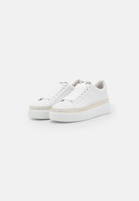 Sneakers bianchi con tomaia in pelle liscia, design con lacci, suola piattaforma elevata e un accento trasparente con rifiniture dorate.