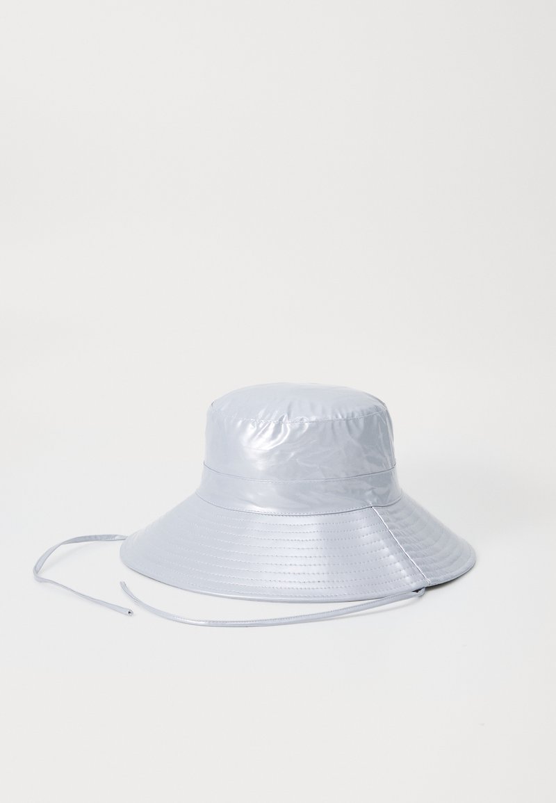 Silberner Bucket Hat aus glänzendem, glattem Material mit breiter Krempe und verstellbarem Kinnriemen, der ein gesticktes Muster an der Krempe aufweist.