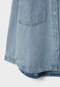 Lichtblauwe denimjack met een zichtbare achterzak, opgerolde mouw en zichtbare dubbele stiksels langs de zoom en de zijnaad.
