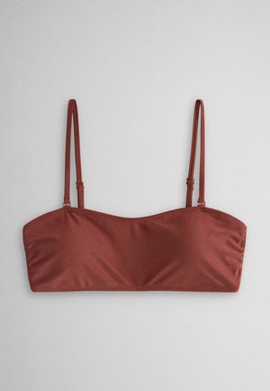 Bandeau-Bikinitop in Rostfarbe mit dünnen verstellbaren Schulterriemen, vor hellem grauem Hintergrund.