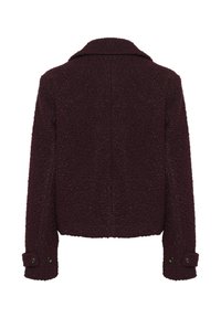 Burgundská bunda vyrobená z texturované tkaniny. Má límec, dlouhé rukávy s knoflíkovými manžetami a zkrácený střih.