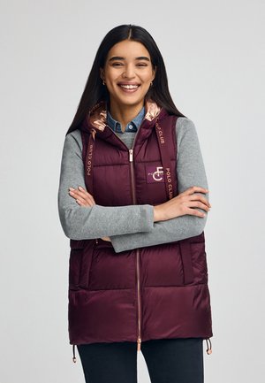Chaleco acolchado burdeos con capucha, que cuenta con un forro brillante en oro rosa, cierre de cremallera y la marca "Polo Club" en las correas y el pecho.
