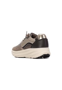 Sneaker beige e nera con tomaia in mesh testurizzato, colletto imbottito, dettaglio lucido sul tallone e suola spessa color crema con battistrada nera.
