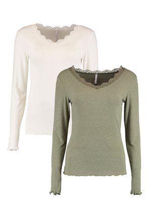 Zwei Langarmoberteile: eines in Weiß und eines in Olivgrün. Beide haben einen Wellenrand aus Spitze am Ausschnitt und eine gerippte Textur mit frillierten Manschetten.