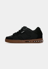 Sorte sneakers lavet af læder og syntetiske materialer, med en brun gummisål, polstret krave og tekstureret detaljer.