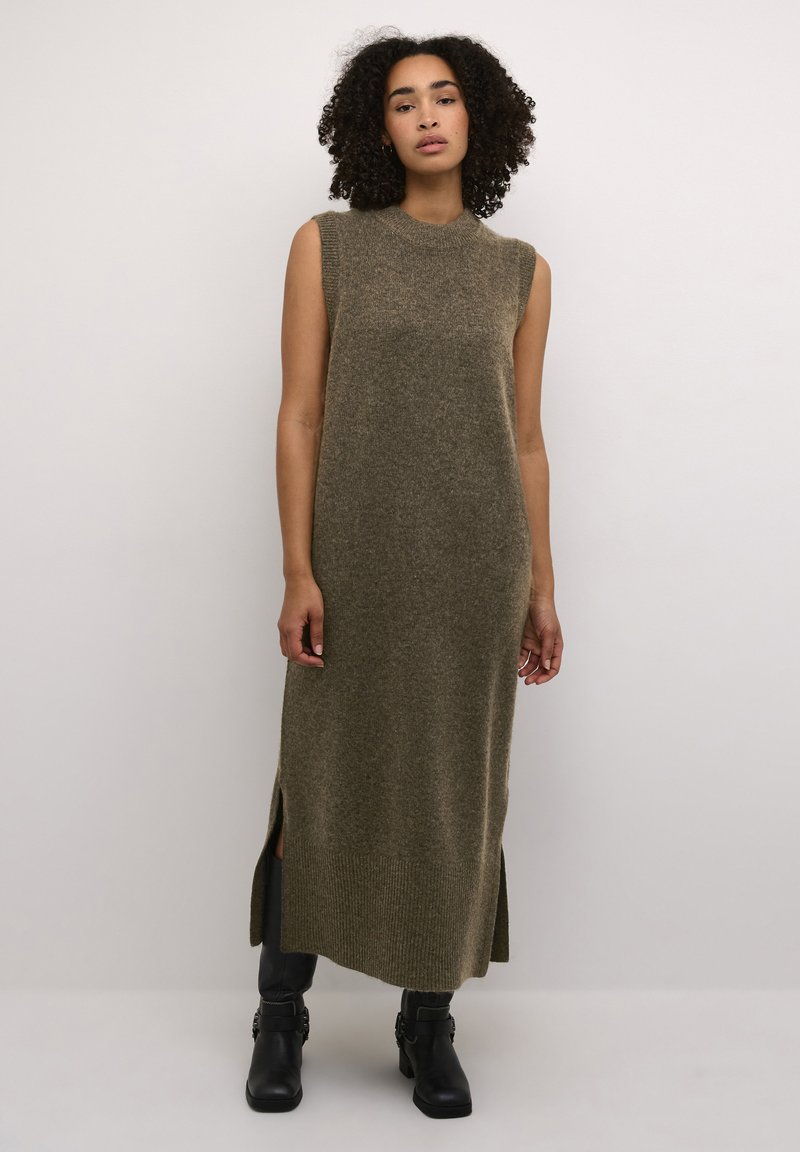 Robe longue sans manches en vert olive, fabriquée en matériau tricot doux. Présente des fentes sur les côtés et un ourlet côtelé pour plus de texture et de détails.