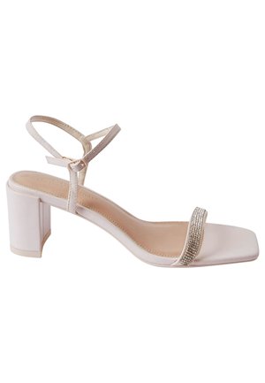 Square-toed block heel sandal in off-white, featuring a decorative rhinestone strap, and thin ankle straps for secure fit. Smooth finish throughout.