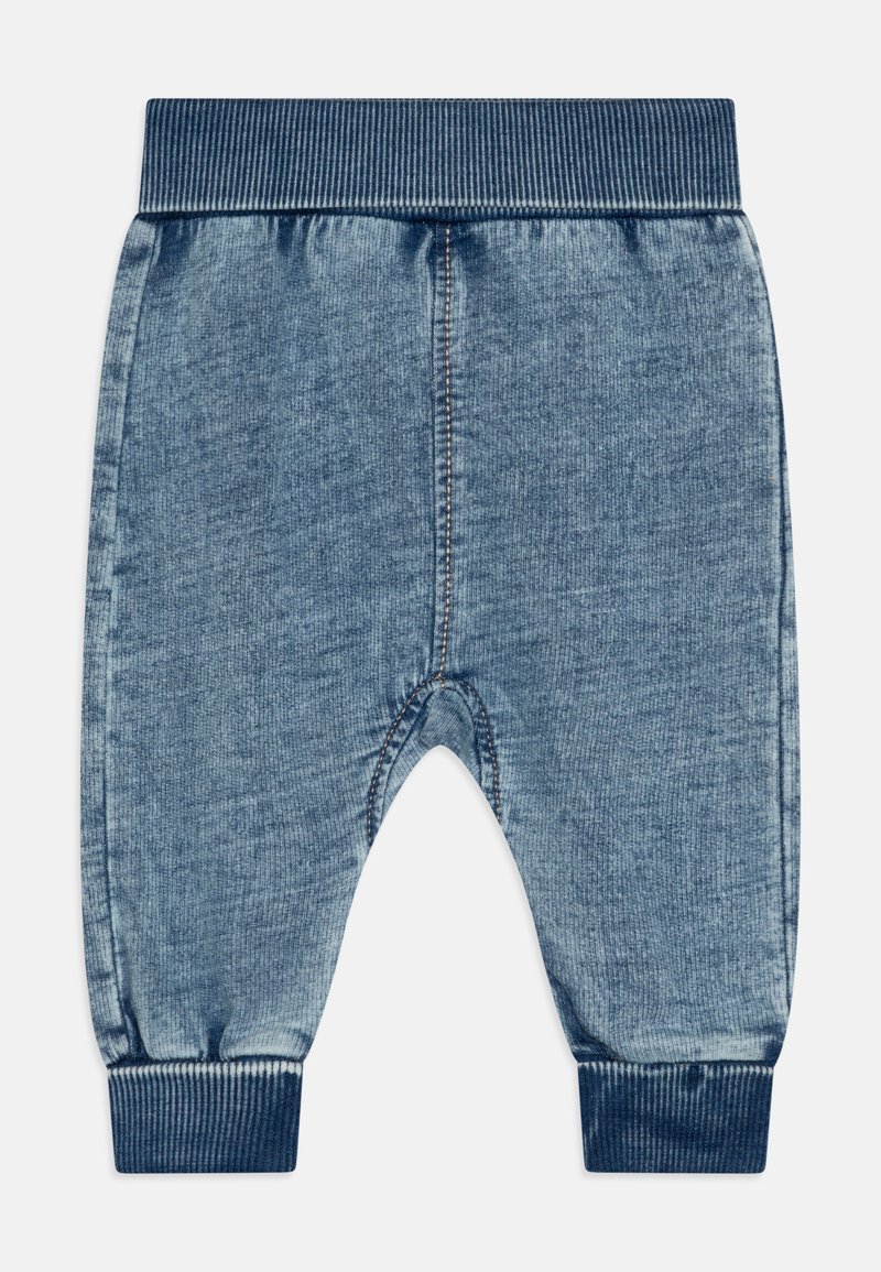 Pantaloni jogger in denim blu con cintura e polsini a coste. Caratterizzati da una texture morbida e cuciture tonali. La forma è un fit rilassato con stile a cavallo basso.
