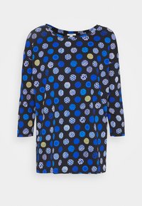Schwarze Tunika mit drei Viertelärmeln, die ein Muster aus blauen, weißen und goldenen Kreisen mit unterschiedlichen Größen und Texturen zeigt.