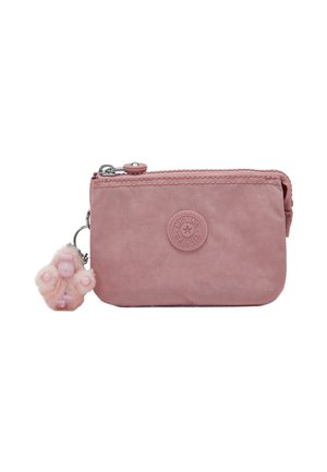 Pequeña bolsa rectangular rosa con cremallera, con un logo redondo en el centro y un llavero esponjoso en forma de pata.