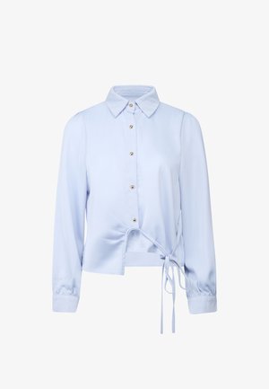 Lyseblå bluse med lange ærmer, knapper foran, en spids krave og en snørede detalje i taljen.