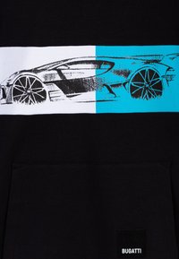 Felpa nera con una banda orizzontale bianca e blu e un disegno di un'auto, e un piccolo etichetta nera con il logo "BUGATTI".