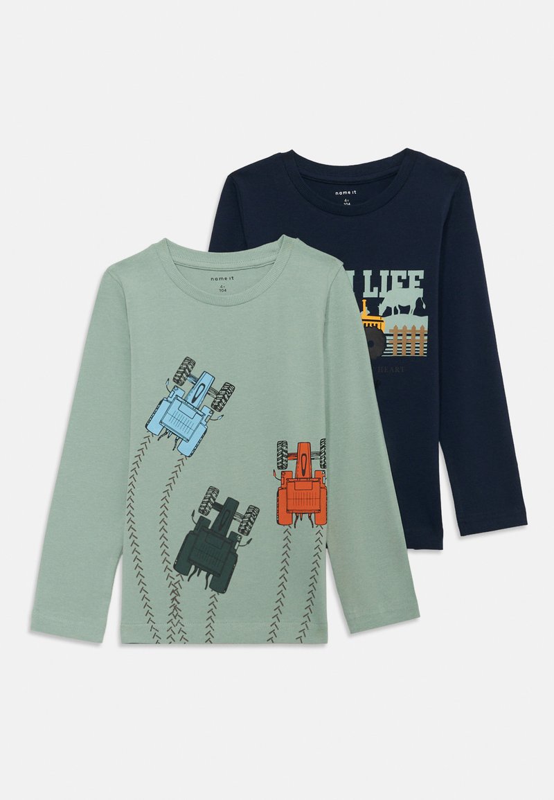 Zwei Langarm-T-Shirts: eines grün mit Traktor-Grafiken und Reifenspuren, das andere marineblau mit landwirtschaftlichem Text und Tiermuster.
